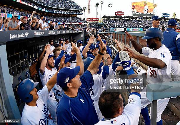 Andrew Toles of the Los Angeles Dodgers celebrates with teammates in the eighth inning after scoring on a single by Chase Utley during game four of...
