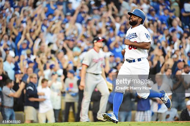Andrew Toles of the Los Angeles Dodgers scores on a single by Chase Utley as Oliver Perez of the Washington Nationals looks on in the eighth inning...
