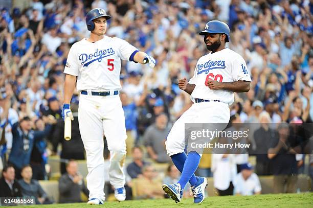 Andrew Toles of the Los Angeles Dodgers celebrates with Corey Seager after scoring on a single by Chase Utley in the eighth inning during game four...