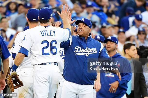 Manager Dave Roberts celebrates with Chase Utley of the Los Angeles Dodgers after they defeated the Washington Nationals 6 to 5 during game four of...