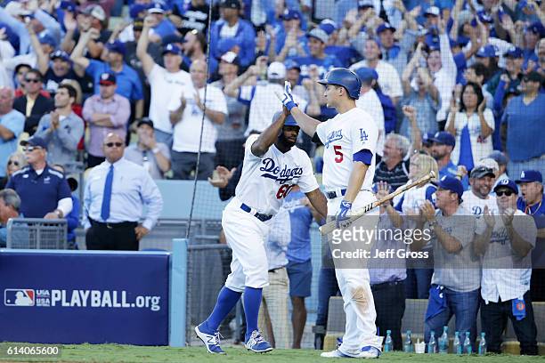 Andrew Toles of the Los Angeles Dodgers celebrates with Corey Seager after scoring on a single by Chase Utley in the eighth inning during game four...