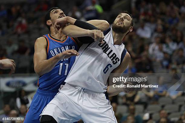 Enes Kanter of the Oklahoma City Thunder and Andrew Bogut of the Dallas Mavericks battle during a preseason game at American Airlines Center on...