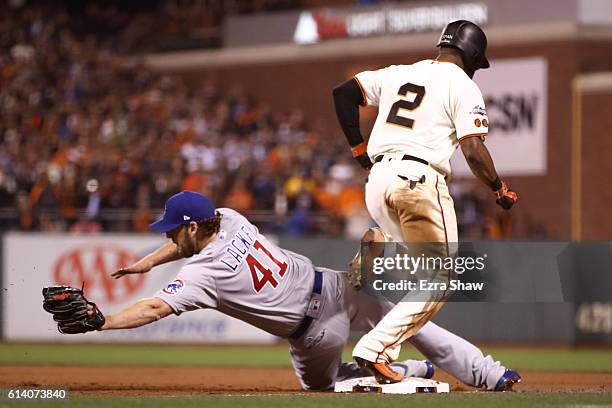 John Lackey of the Chicago Cubs is unable to make the play against Denard Span of the San Francisco Giants at first base in the fourth inning of Game...