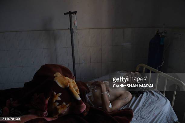 An Afghan wounded man receives treatment at the Ali Abad hospital after an attack by gunmen inside the Karte Sakhi shrine in Kabul on October 12,...