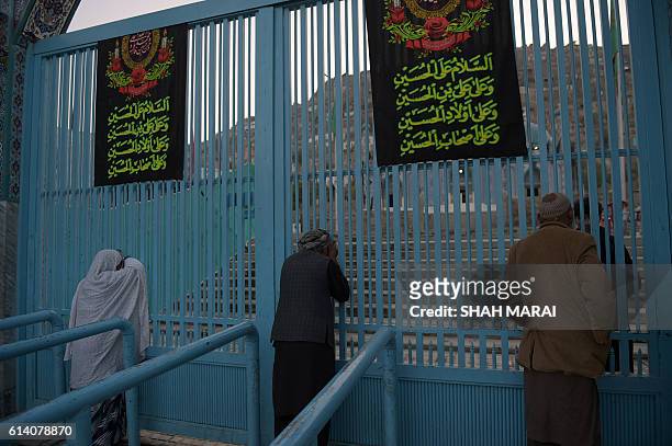 An Afghan man who lost his father an attack by gunmen weeps at the main gate of the Karte Sakhi shrine in Kabul on October 12, 2016. Gunmen targeted...