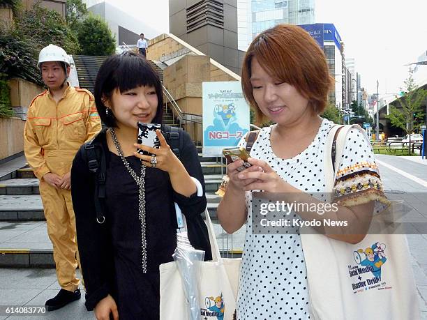 Japan - Women take part in a disaster mitigation drill in Tokyo on Sept. 19 using microblogging site Twitter for purposes such as finding shelters...