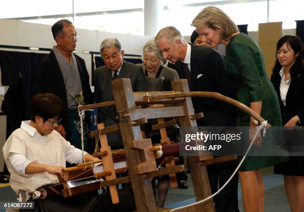 Belgium's King Philippe and Queen Mathilde and Japan's Emperor Akihito and Empress Michiko look at a demonstration to create a traditional woven silk...