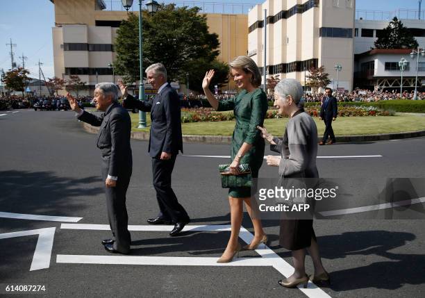 Belgium's King Philippe and Queen Mathilde and Japan's Emperor Akihito and Empress Michiko wave to well-wishers upon their arrival at the Yuki...