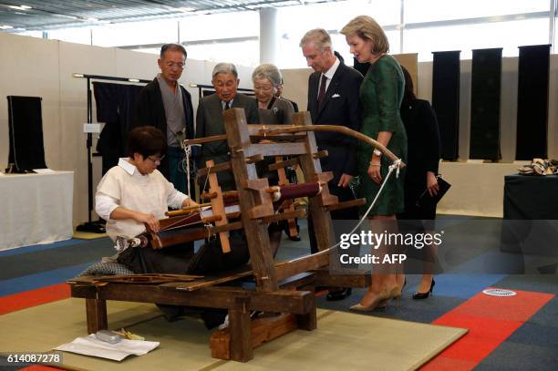 Belgium's King Philippe and Queen Mathilde and Japan's Emperor Akihito and Empress Michiko look at a demonstration to create a traditional woven silk...