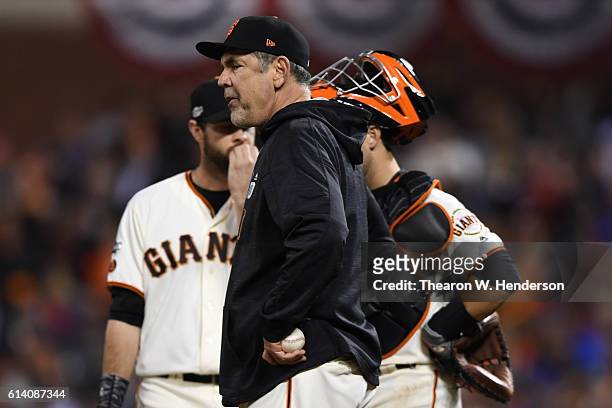 Bruce Bochy of the San Francisco Giants stands on the pitchers mound during a change in the ninth inning of Game Four of their National League...