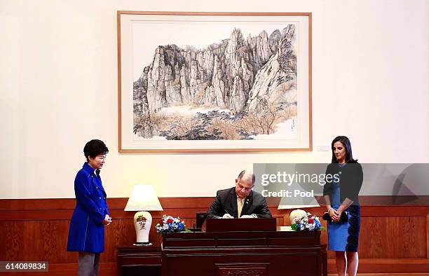 Costa Rican President Luis Guillermo Solis signs a guestbook as South Korean President Park Geun-Hye and Costa Rican first lady Mercedes Pena look...