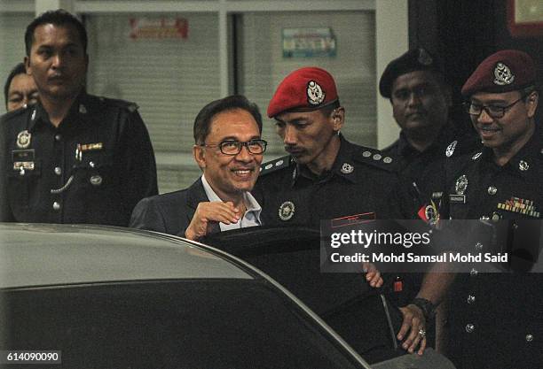 Malaysian former opposition leader Anwar Ibrahim is escorted by prison officers near the court lock-up after his hearing in sodomy case on October...