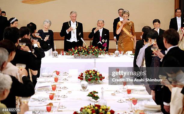 Empress Michiko, King Philippe of Belgium, Emperor Akihito and Queen Mathilde of Belgium toast their glasses during the state dinner at the Imperial...