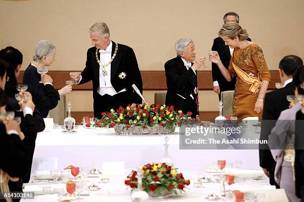 Empress Michiko, King Philippe of Belgium, Emperor Akihito and Queen Mathilde of Belgium toast their glasses during the state dinner at the Imperial...