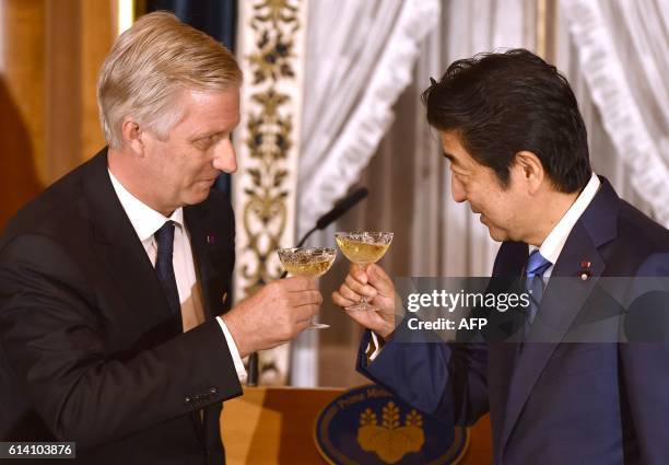 Belgium's King Philippe toasts Japan's Prime Minister Shinzo Abe at the opening of a dinner at state guest house in Tokyo on October 12, 2016. The...