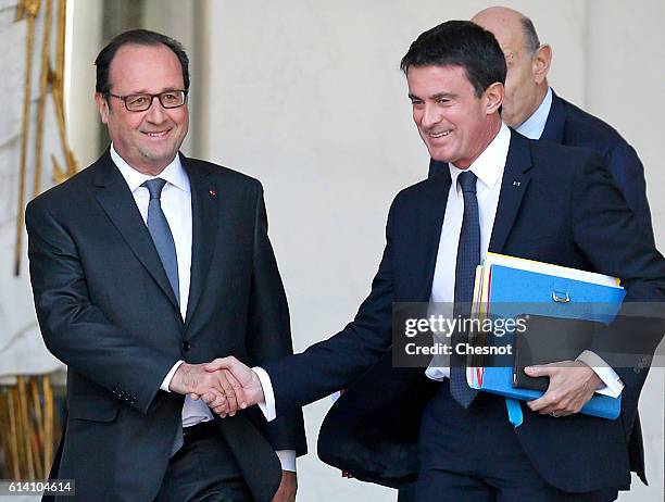 French President, Francois Hollande shakes hands with French Prime minister, Manuel Valls after a weekly cabinet meeting at the Elysee Presidential...