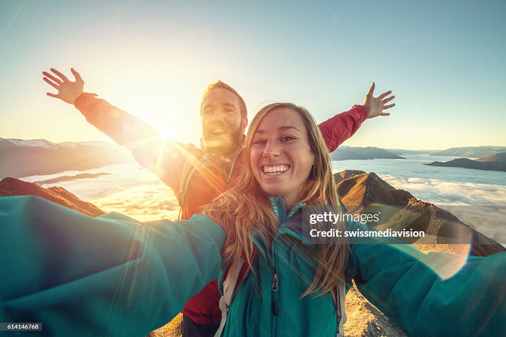 Fröhliches junges Paar auf dem Berg top selfie nehmen