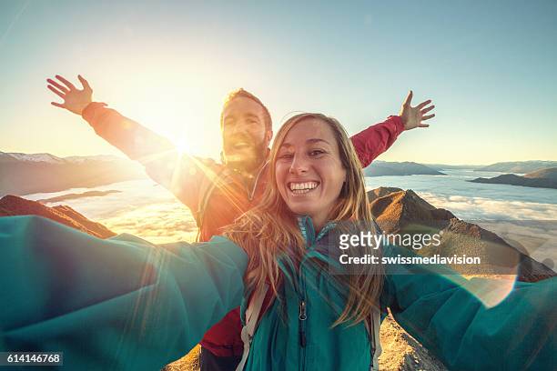 cheerful young couple on mountain top take selfie - man woman top view stockfoto's en -beelden