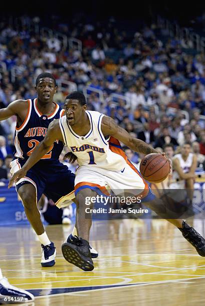 Guard Orien Greene of the Florida Gators drives to the basket against the defense of guard Lewis Monroe of the Auburn Tigers during the first round...