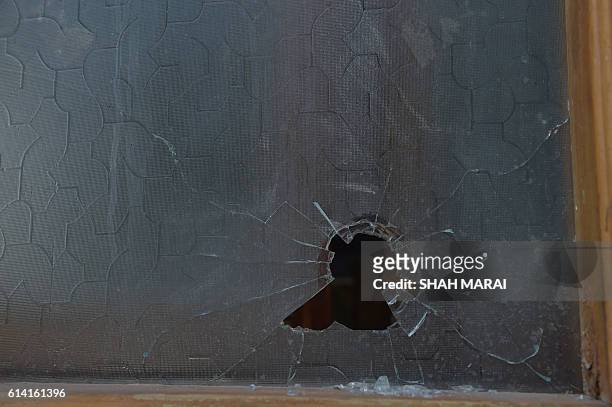 Bullet hole is seen on a window of the Karte Sakhi shrine in Kabul on October 12, 2016 after an attack by gunmen late on October 11. Grieving...
