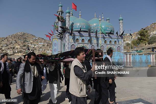 Afghan mourners carry the coffin of a victim in Kabul on October 12 who was killed in an attack by gunmen inside the Karte Sakhi shrine late on...