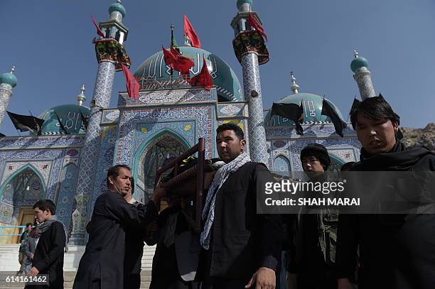 Afghan mourners carry the coffin of a victim in Kabul on October 12 who was killed in an attack by gunmen inside the Karte Sakhi shrine late on...