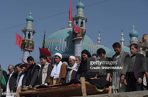Afghan mourners offer funeral prayers for a victim in Kabul on October 12 who was killed in an attack by gunmen inside the Karte Sakhi shrine late on...