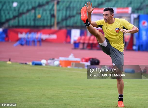 Goa's defender Lucio stretches as he takes part in a practice session at the Jwaharlal Nehru Athletic Stadium in Chennai on October 12 ahead of the...