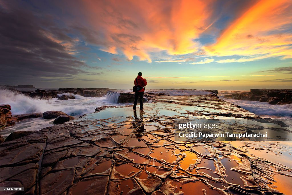 Seascape photographer taking stunning sunrise