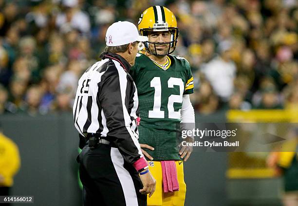 Aaron Rodgers of the Green Bay Packers talks with referee Ed Hochuli in the first quarter against the New York Giants at Lambeau Field on October 9,...