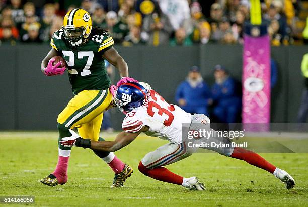 Eddie Lacy of the Green Bay Packers fends off Andrew Adams of the New York Giants in the second quarter at Lambeau Field on October 9, 2016 in Green...