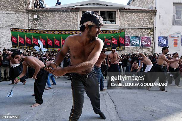 Shiite Muslim men, part of the migrant community currently living in Piraeus, near Athens, use chains and blades during a self-flagellation ritual to...