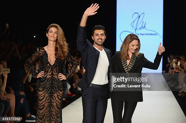 Model Tulin Sahin, designer Rasit Bagzibagli and Demet Sener walk the runway at the Rasit Bagzibagli show during Mercedes-Benz Fashion Week Istanbul...