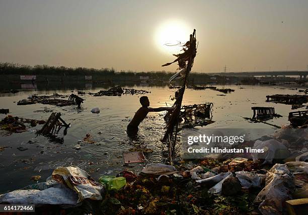 Locals scavenge for the remains of Goddess Durga idols after the immersion in the River Yamuna near ISBT, on October 12, 2016 in New Delhi, India....