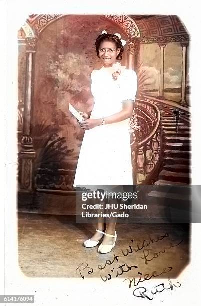 Full length portrait of young African-American woman in white knee-length dress, standing in front of fresco, 1920. Note: Image has been digitally...