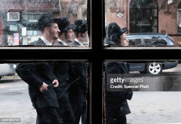 Members of an Orthodox Jewish community in Williamsburg, Brooklyn walk through the neighborhood on Yom Kippur, one of the most important holidays of...