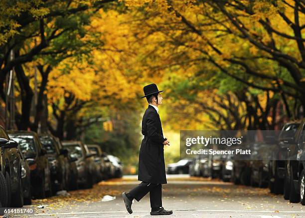 Member of an Orthodox Jewish community in Williamsburg, Brooklyn walks through the neighborhood on Yom Kippur, one of the most important holidays of...