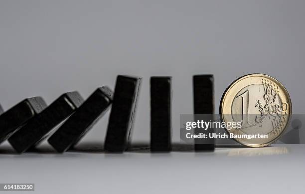 Future of the EU and the euro - - Symbol photo with dominoes falling over and a one euro coin.