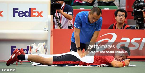 Kei Nishikori of Japan receives medical treatment before his withdrawal during the men's singles second round match against Joao Sousa of Portugal on...