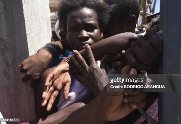 Hurricane Matthew victims wait to receive food from the UN's World Food Programme in Port-Salut, Haiti, on October 12, 2016. The first major handout...