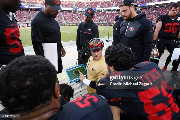 Outside Linebackers Coach Jason Tarver of the San Francisco 49ers talks with Aaron Lynch on the sideline during the game against the Arizona...