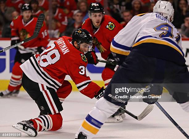 Ryan Hartman of the Chicago Blackhawks scores his first NHL goal past Robert Bortuzzo of the St. Louis Blues during the season opening game at the...