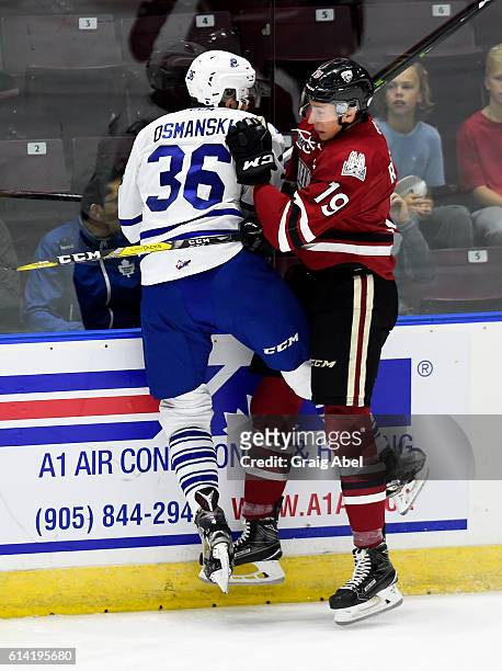 Austin Osmanski of the Mississauga Steelheads collides on the boards with Isaac Ratcliffe of the Guelph Storm during game action at Hershey Centre on...