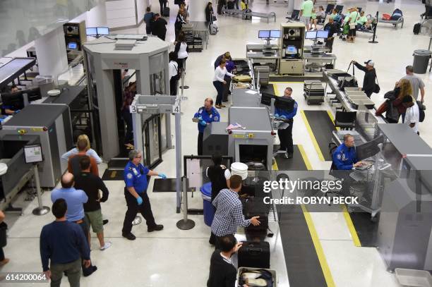 Transportation Security Administration officers inspect airline passengers before they board their flights, at LambertSt. Louis International Airport...