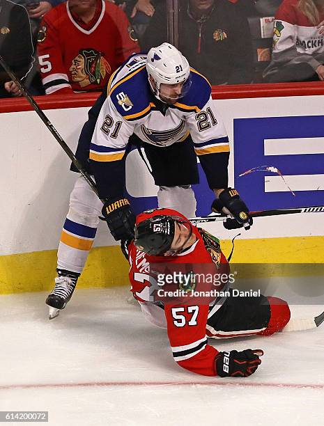 Trevor van Riemsdyk of the Chicago Blackhawks hits the ice after a high stick from Patrik Berglund of the St. Louis Blues during the season opening...
