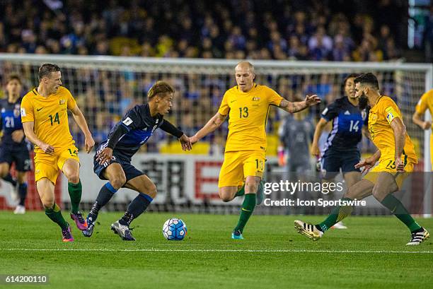 Keisuke Honda of the Japanese Samurai Blue controls the ball in front of Brad Smith of the Australian Socceroos and Aaron Moony of the Australian...