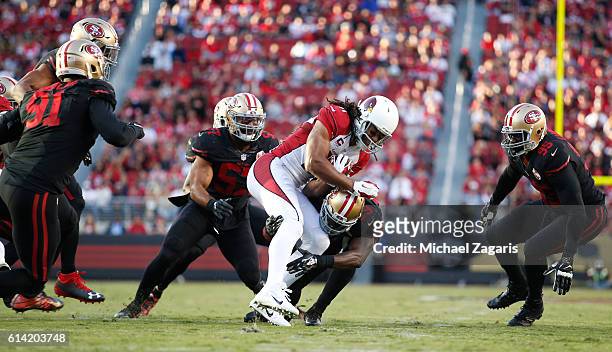 Michael Wilhoite, Jaquiski Tartt and Tank Carradine of the San Francisco 49ers tackle Larry Fitzgerald of the Arizona Cardinals during the game at...