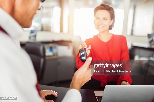 car dealer giving car keys to the client - car rental stockfoto's en -beelden