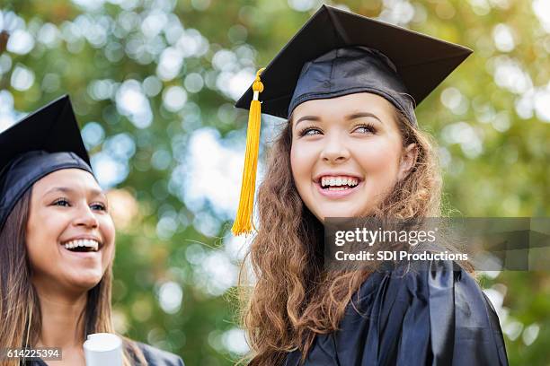 cheerful caucasian college graduate outdoors - graduation gown 個照片及圖片檔