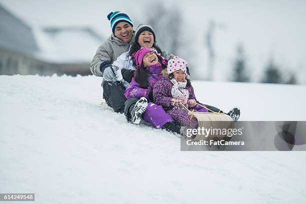 sledding - asian young family stockfoto's en -beelden